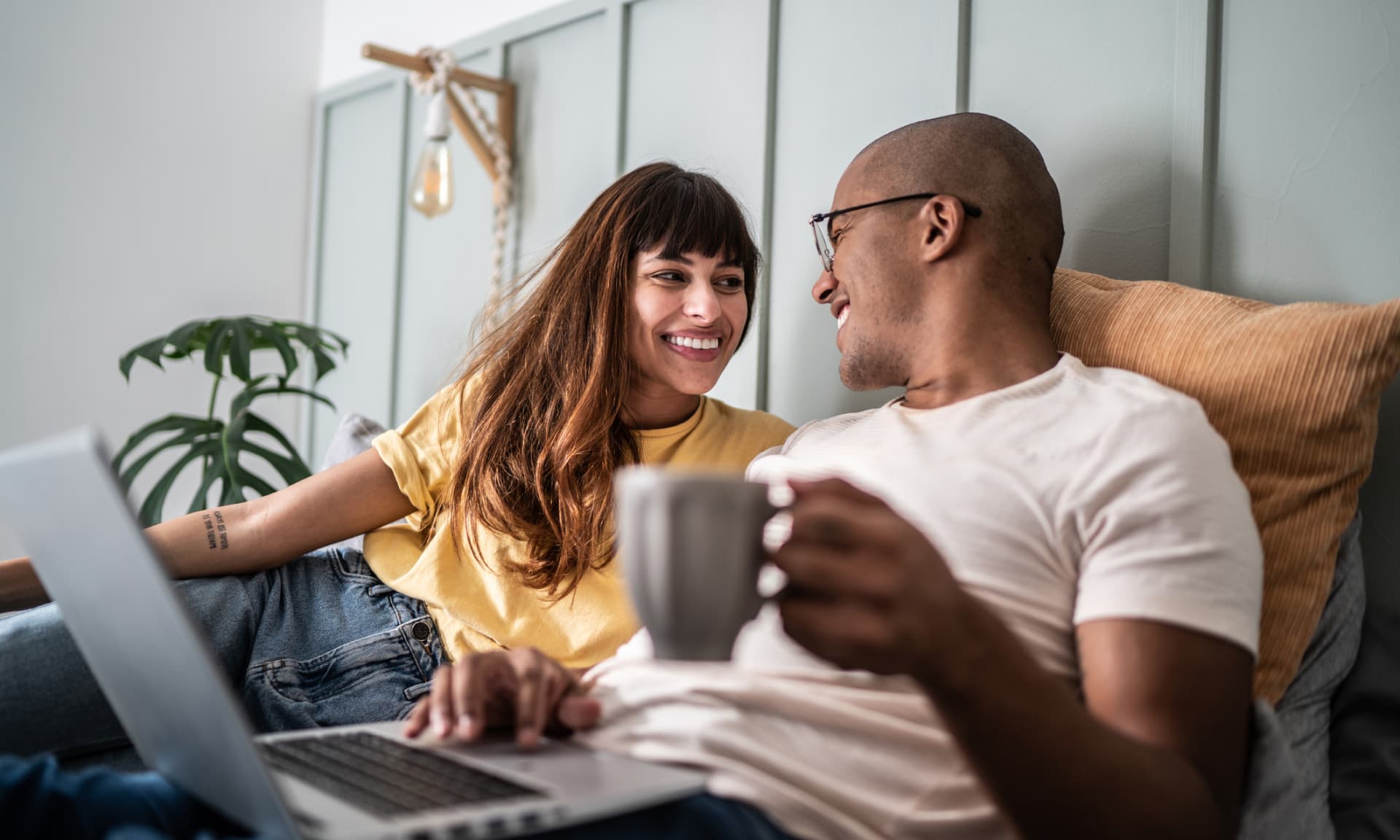 couple in bed together with laptop