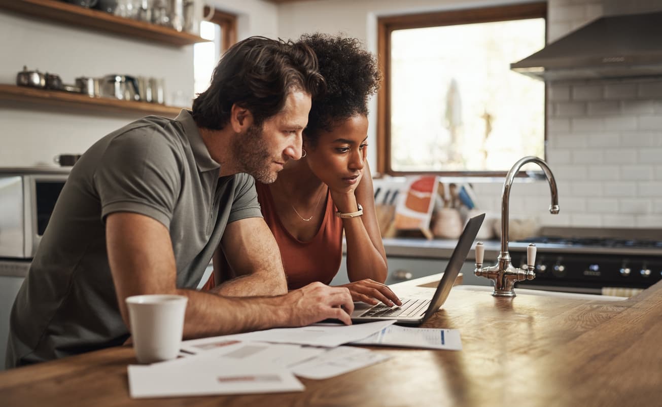 couple in kitchen in front of computer