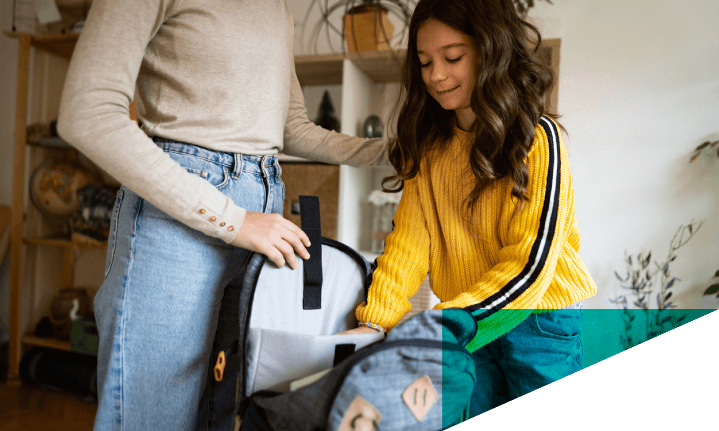 mom helping girl pack up her backpack